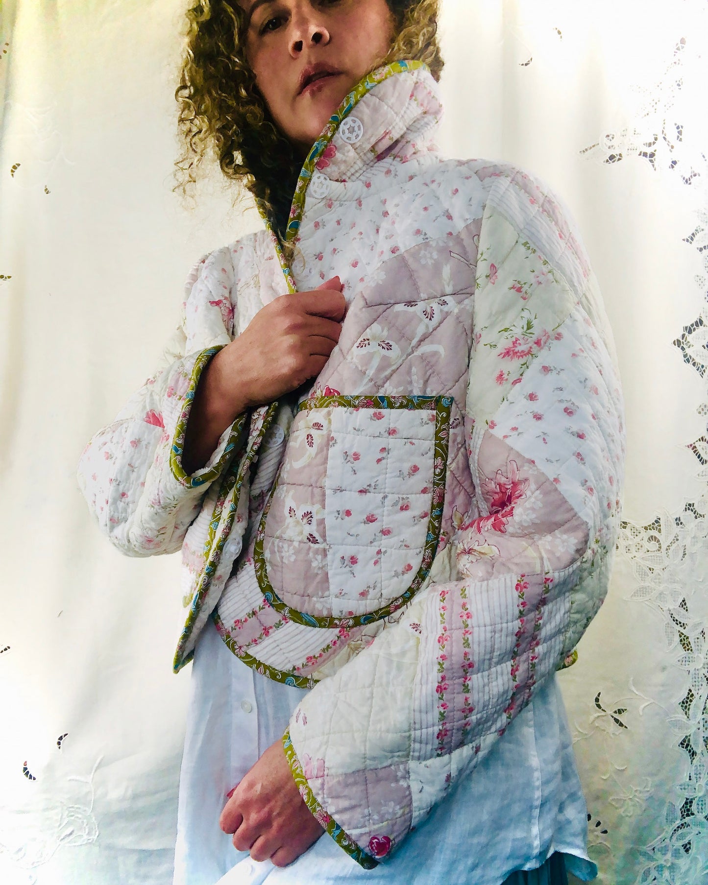 Person wearing a floral handmade quilted jacket made from re purposed materials