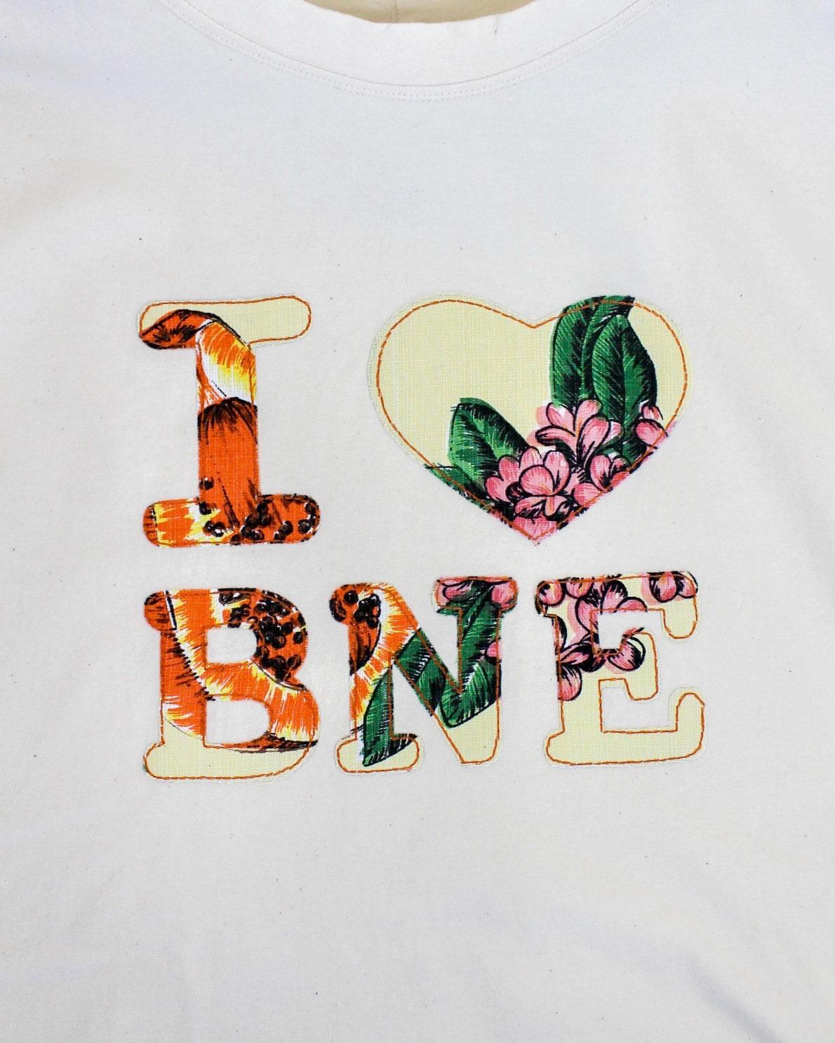 Text 'I ❤️ BNE' with floral and animal print designs on a white background