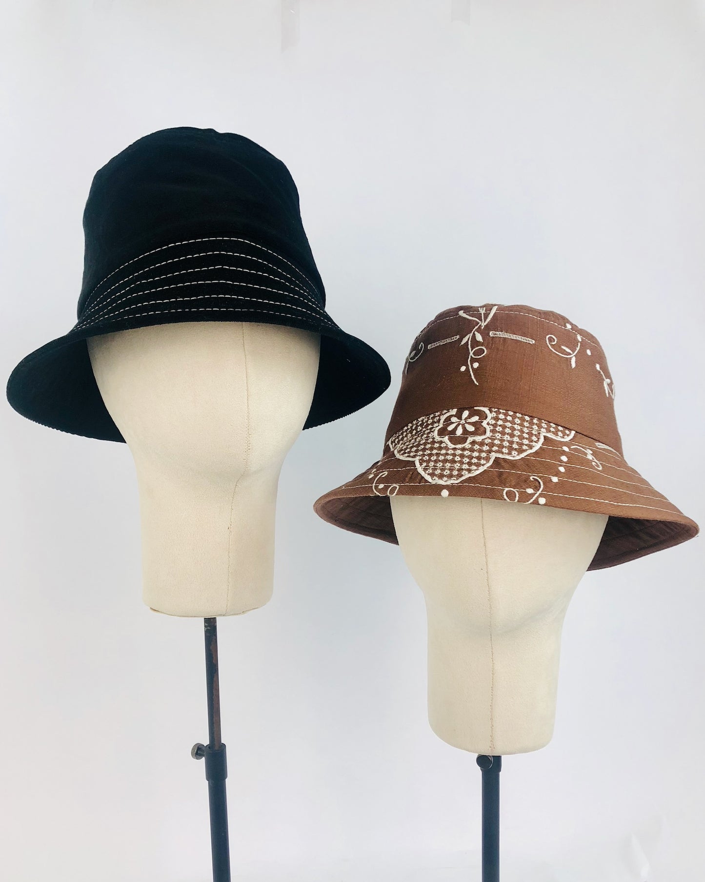 Two handmade bucket hats on hat stands