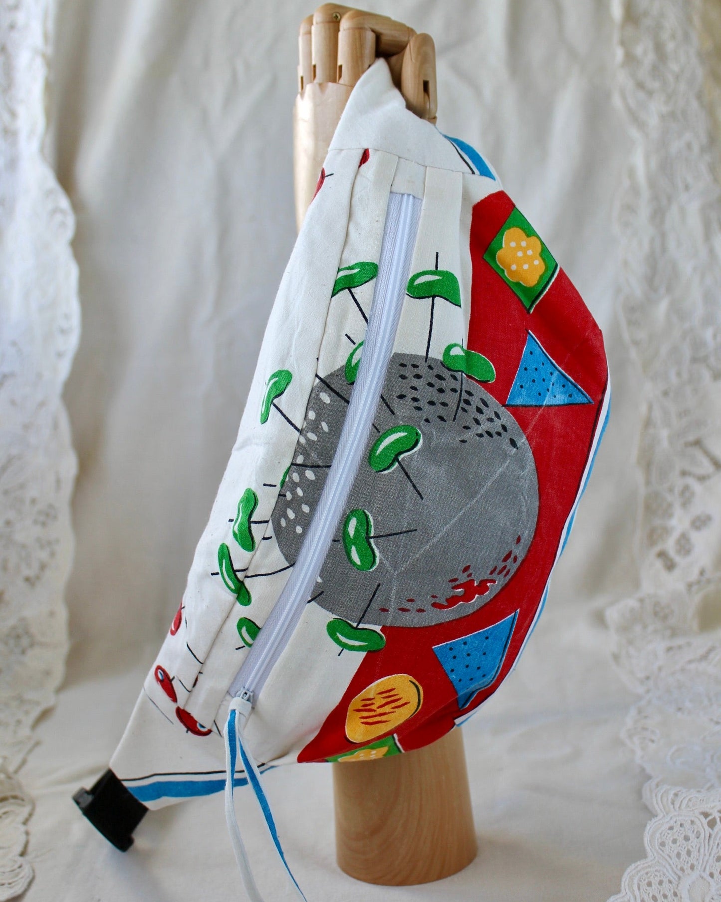 Front view of handmade bumbag made from vintage tea towel featuring and appetisers plate of olives, cheese and chips