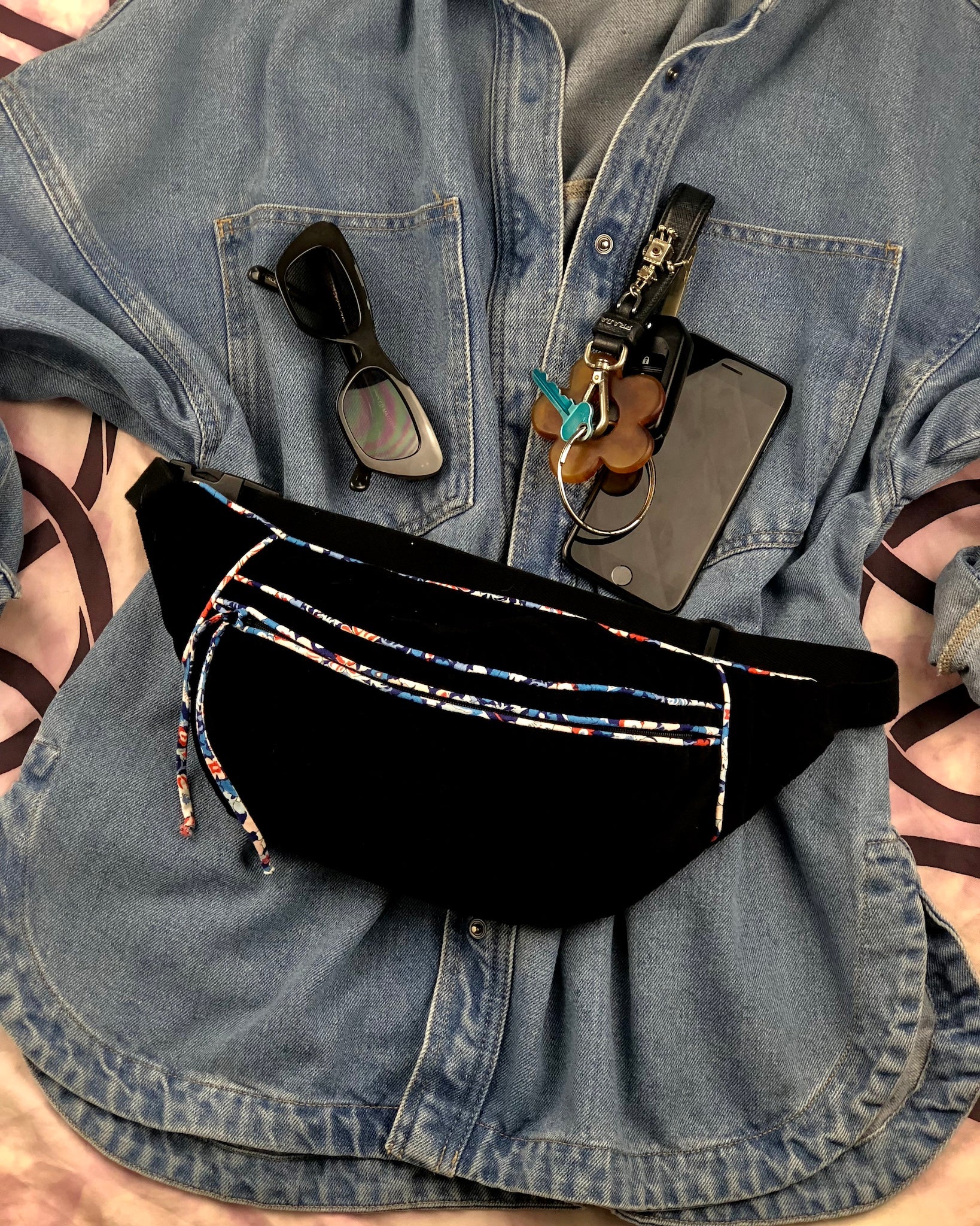 Flat lay of denim shirt with handmade fanny pack made from workroom waster black corduroy