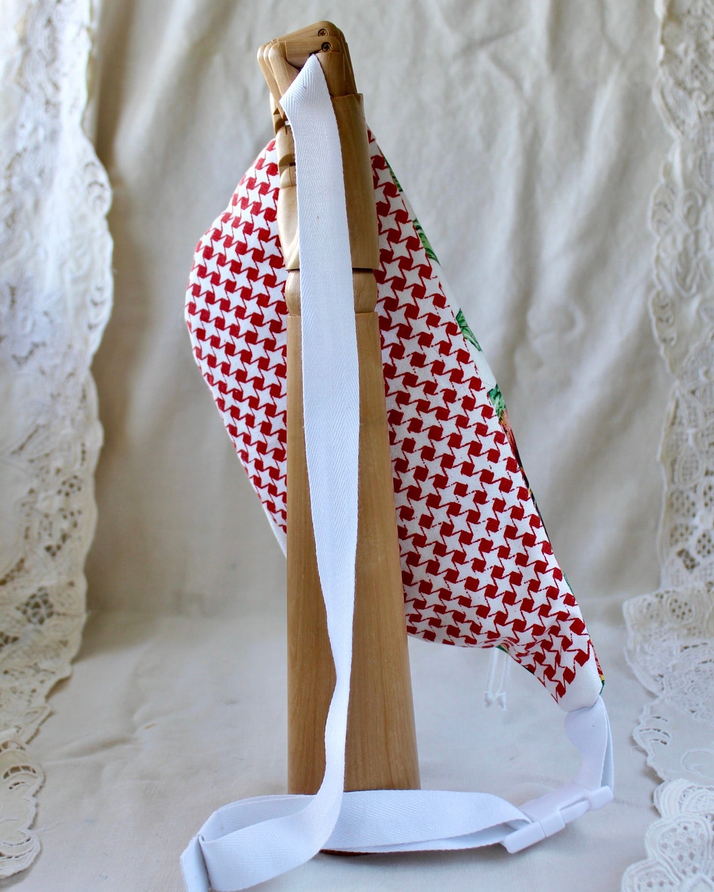 Back view of bumbag featuring red and white houndstooth design and showing the adjustable clip on strap