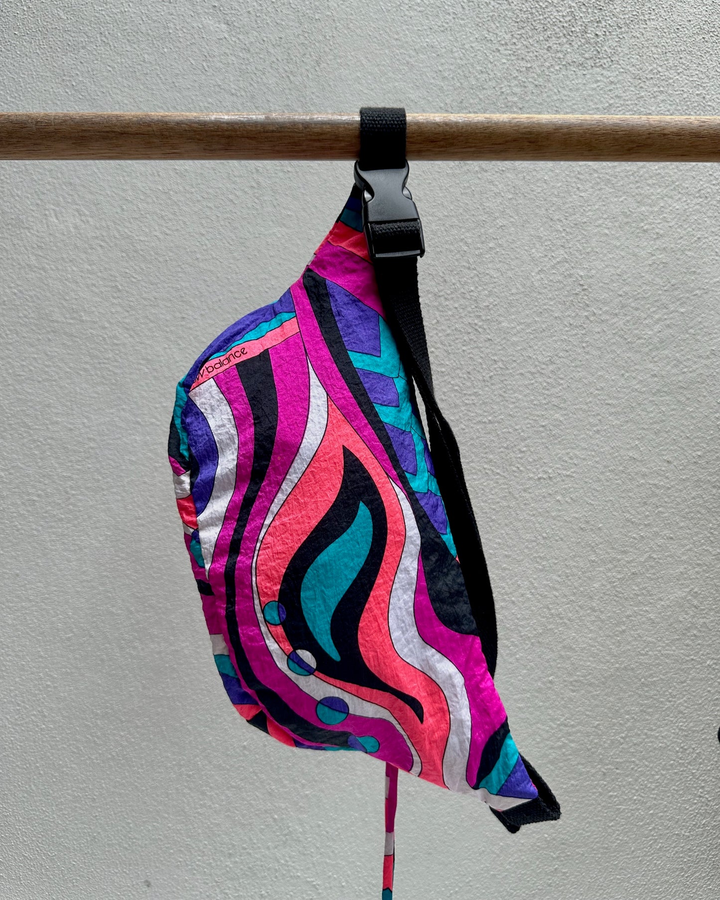 Colorful patterned bag with a strap on a gray background