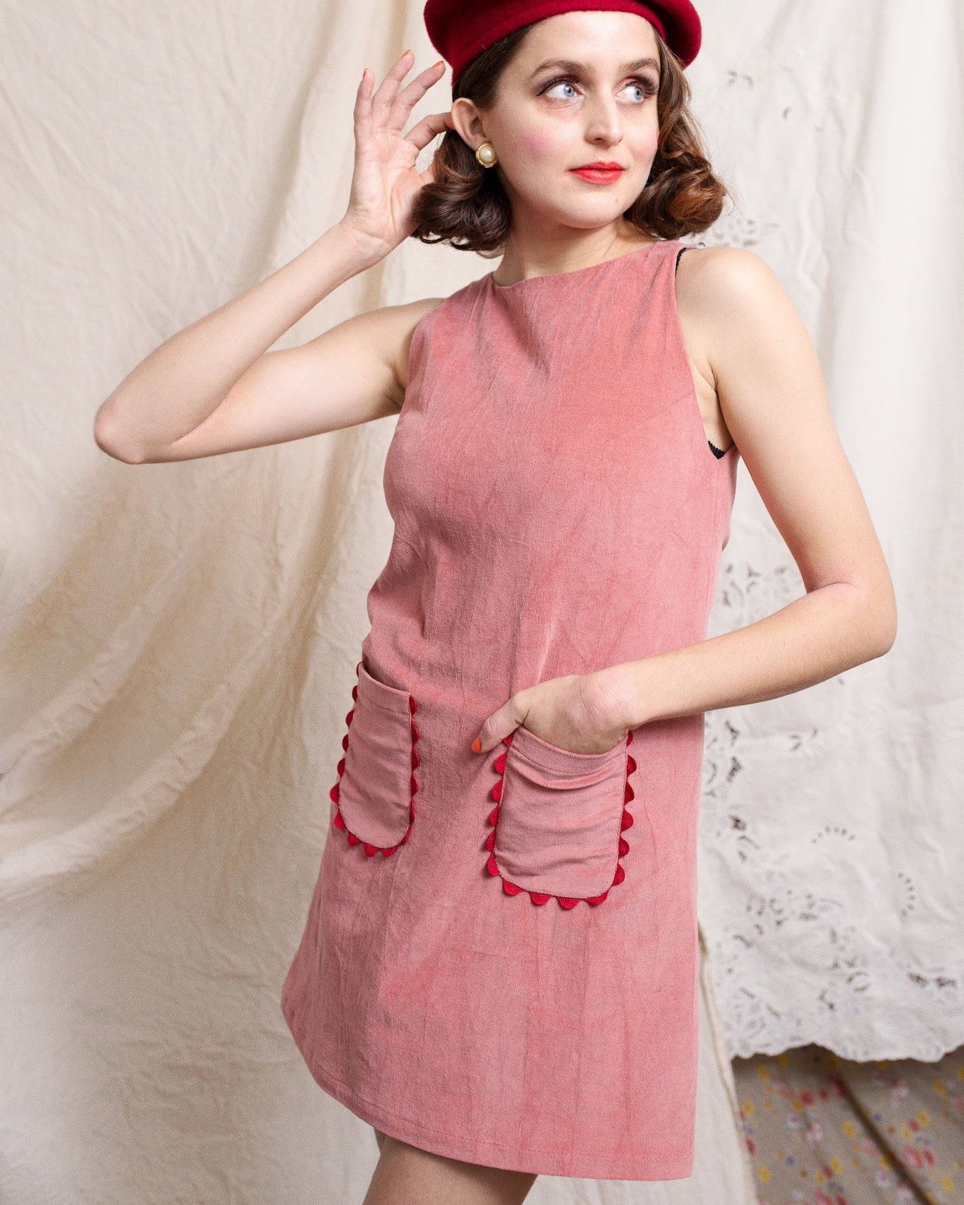 Short sleeveless dress made from dusty pink pinwale corduroy, featuring pockets edgesd with ric rac ribbon