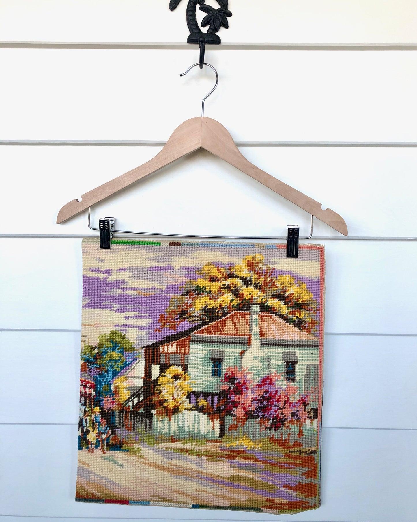 Piece of needlework tapestry in lilacs and earth tones of a country house