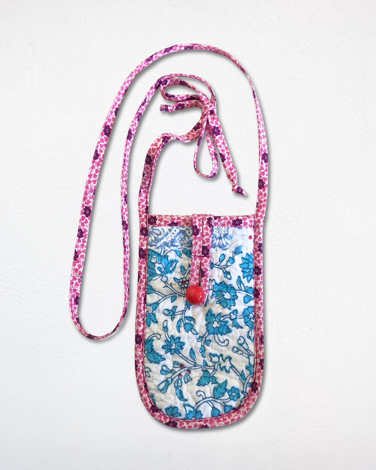 Floral patterned pouch with a strap on a white background