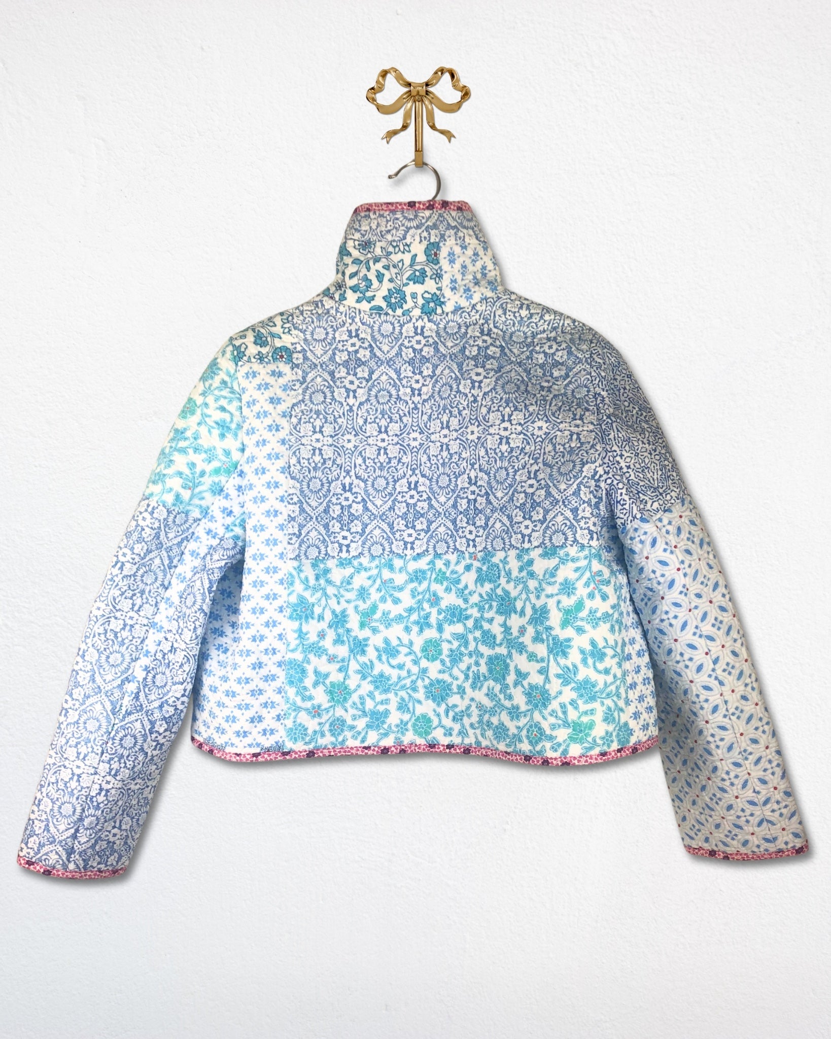 Back view of blue and teal floral patterned jacket on a white background