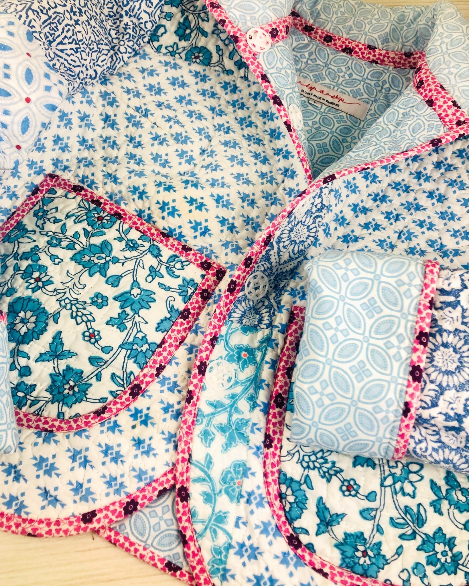 Close-up of a quilted jacket  with floral and geometric patterns laying flat