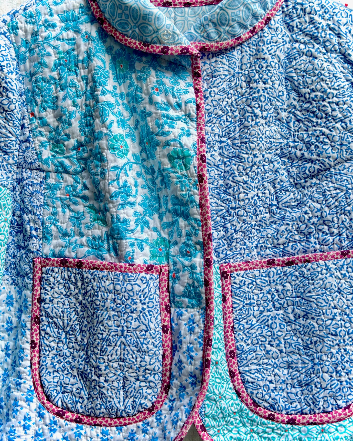 Close-up of a blue and white patterned garment with pink accents