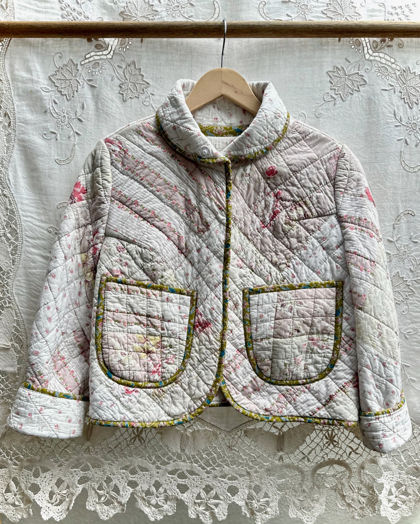 Quilted jacket with floral patterns on a lace background made from a vintage pre loved quilt