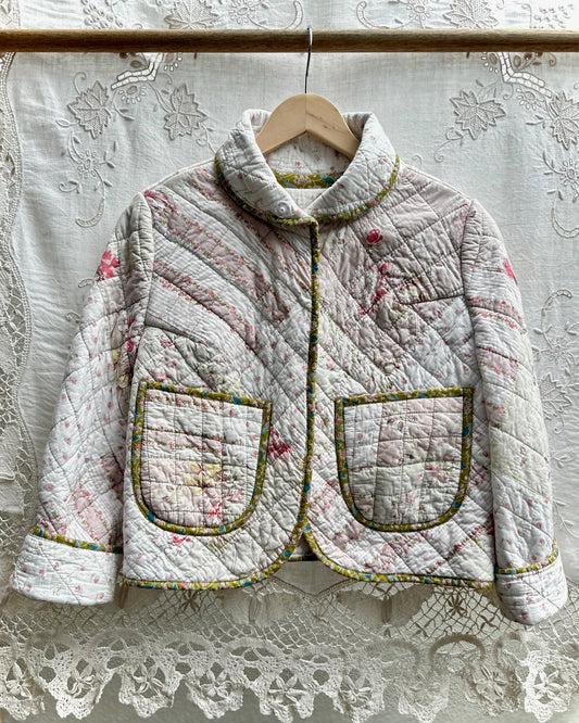 Quilted jacket with floral patterns on a lace background made from a vintage pre loved quilt