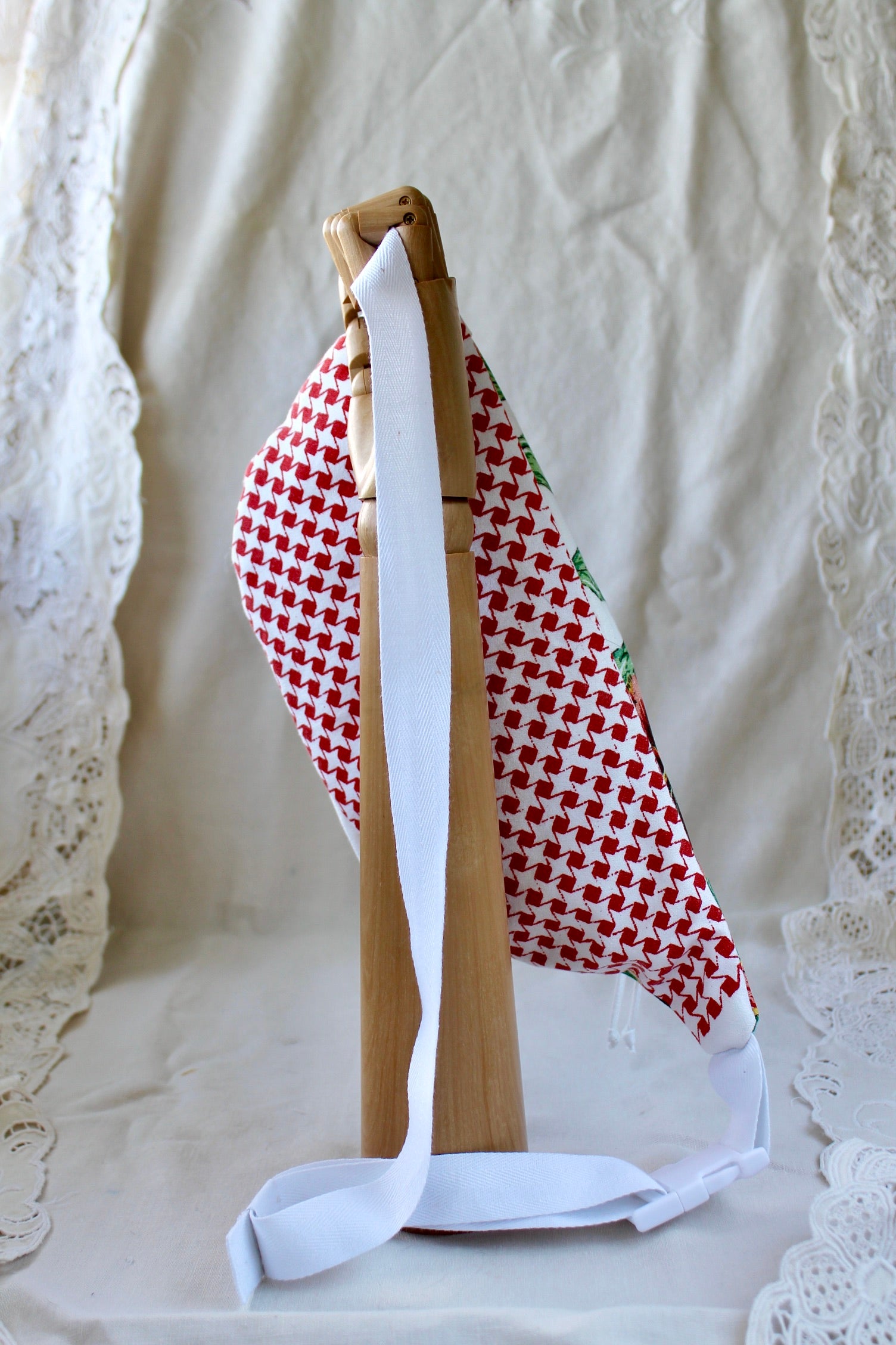 Back view of bumbag featuring red and white houndstooth design and showing the adjustable clip on strap