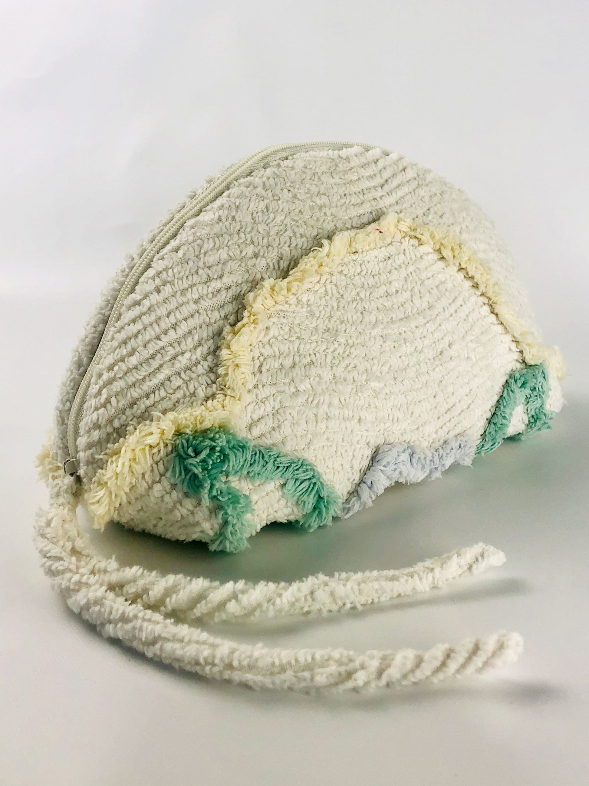 Medium dumpling shaped make up bag made from white chenille with green, yellow and blue tufts