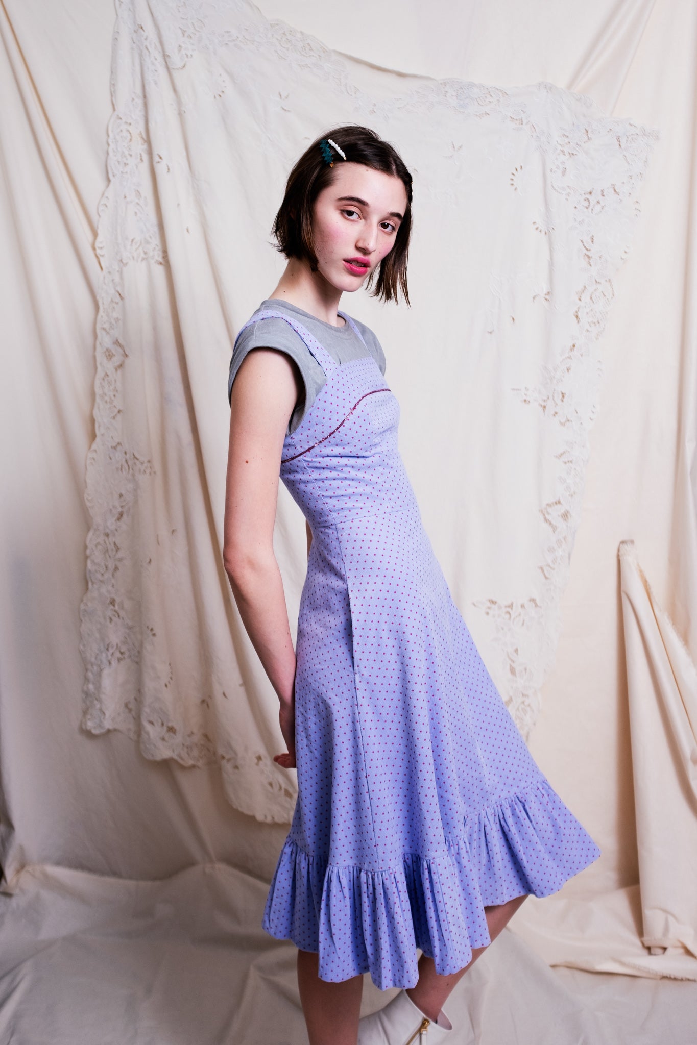 Woman wearing a lilac corduroy dress over a grey shirt