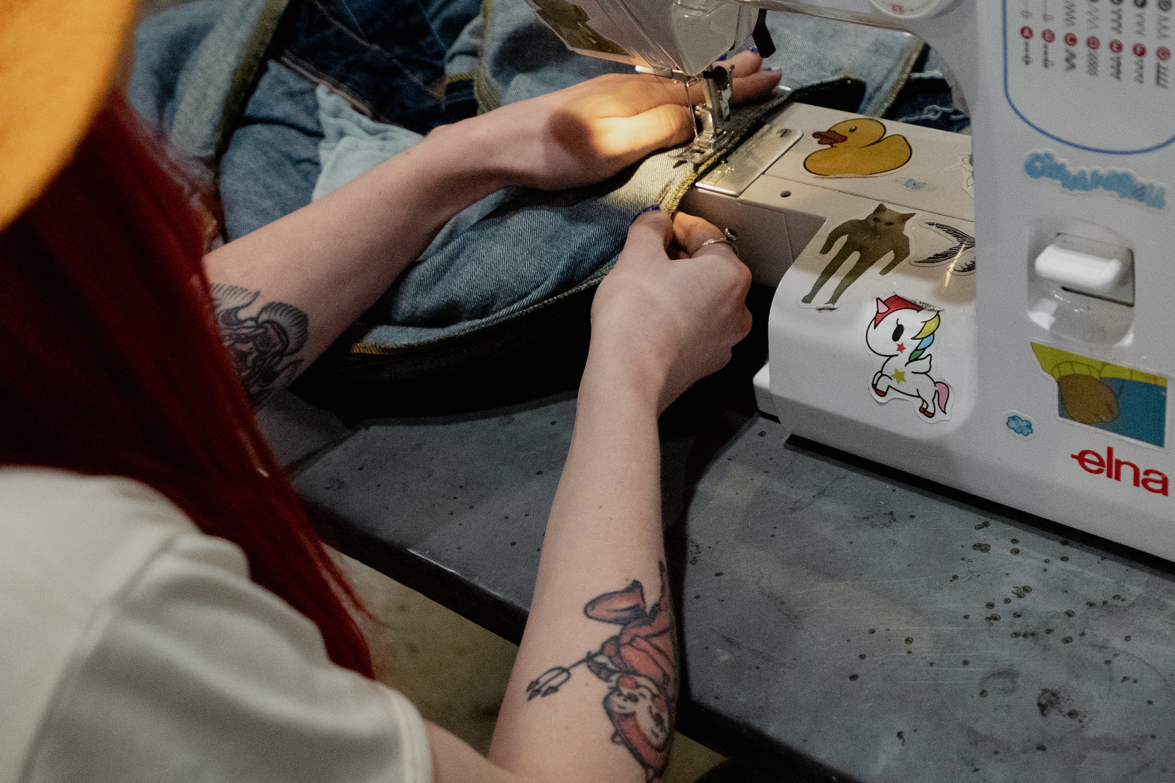 Person using a sewing machine to make alterations for clothing 