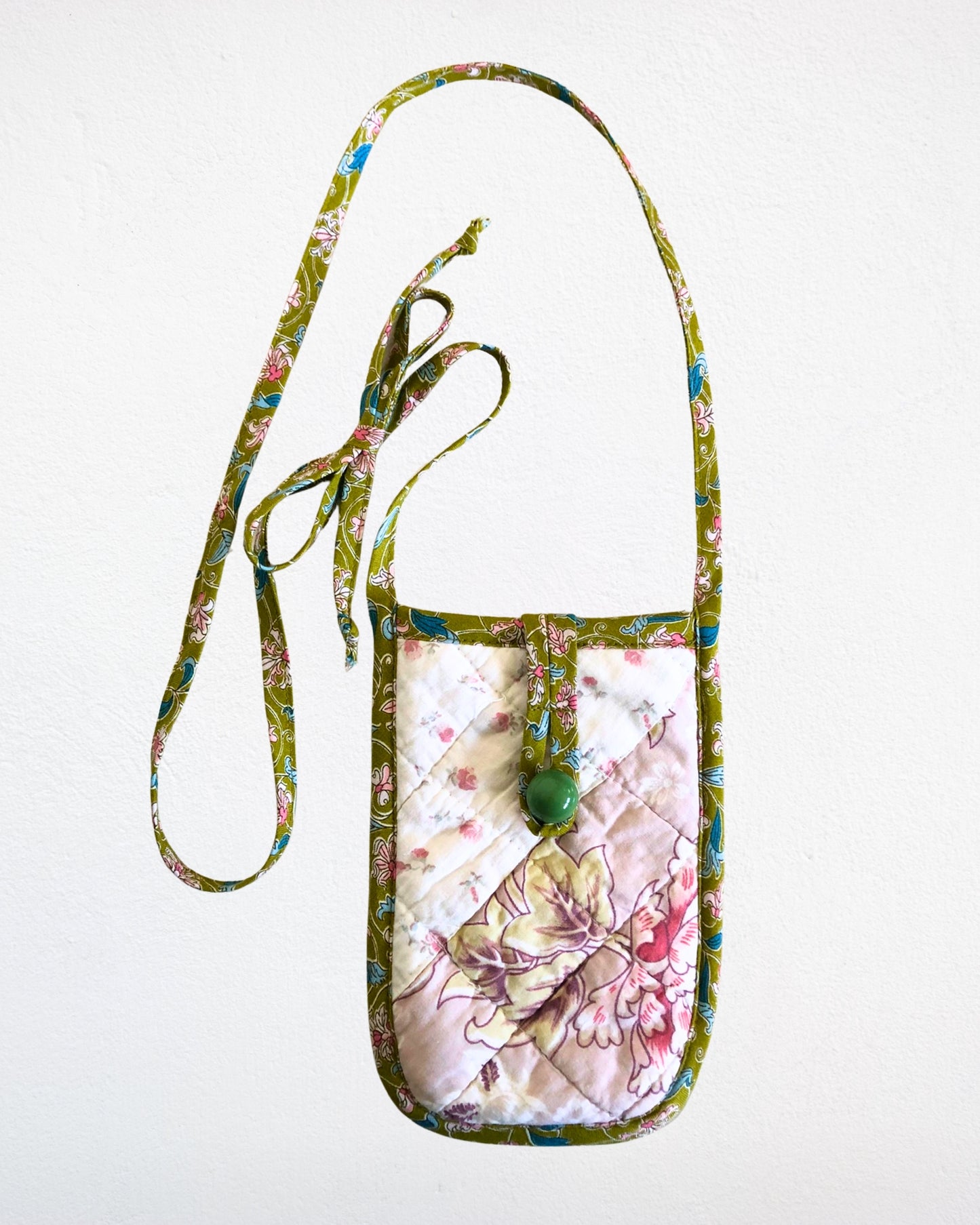 Floral patterned pouch with a strap on a white background