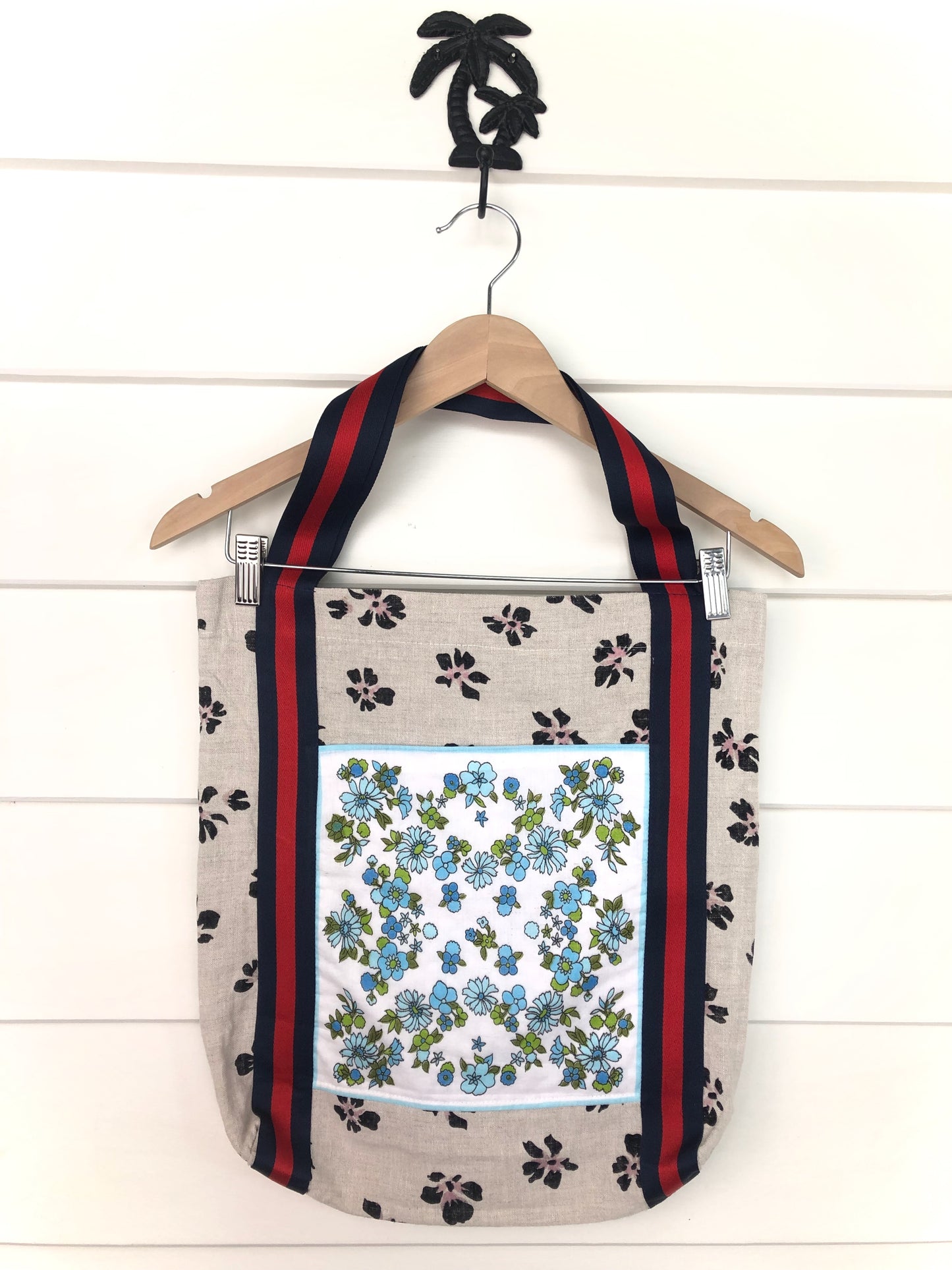 Front view of unique tote bag with sturdy striped red and blue straps and floral design