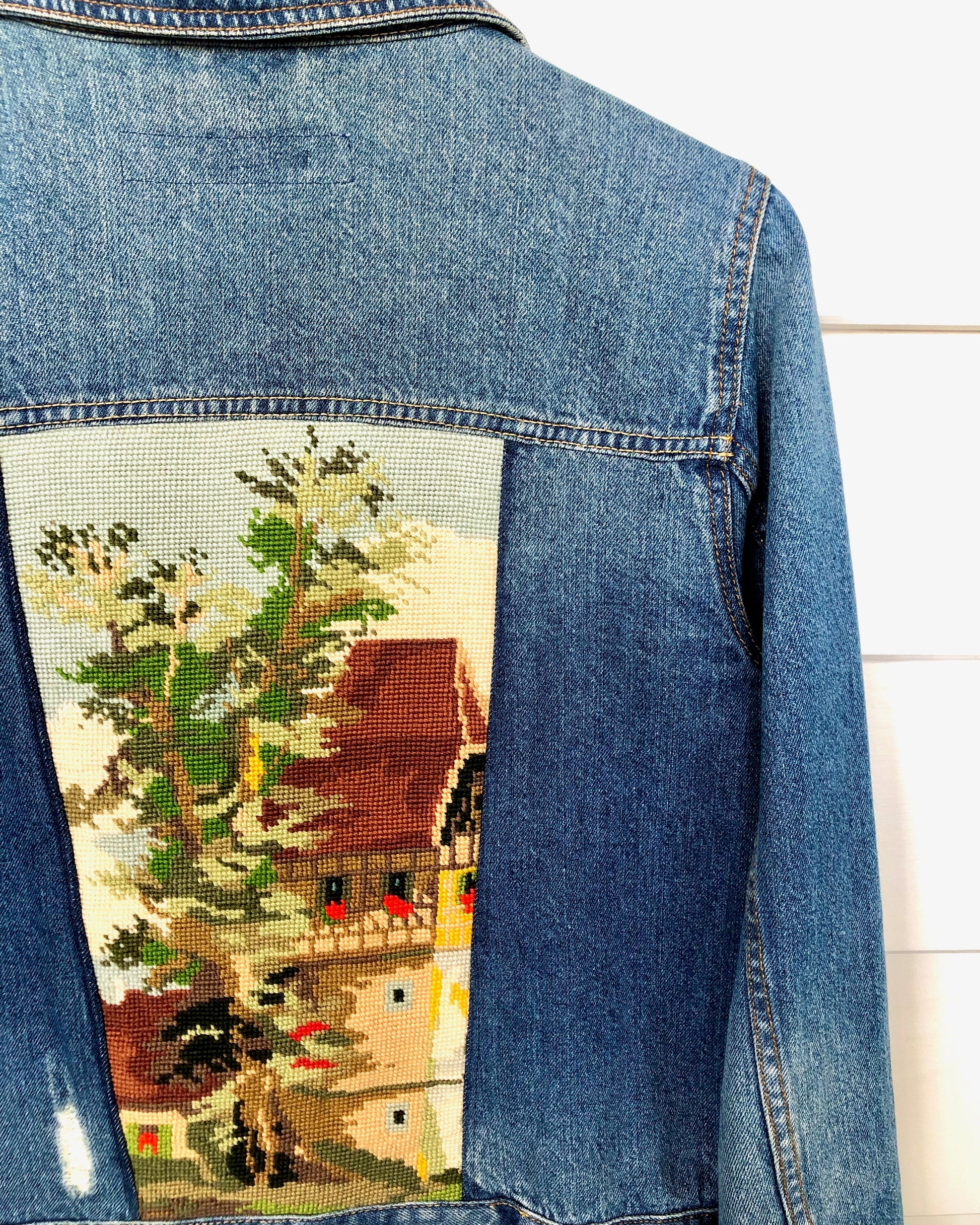 Close up detail of up cycled denim jacket with needlepoint embroidery